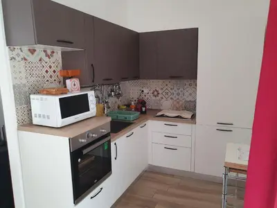 a small kitchen with white cabinets and a microwave at Villa Limone in Castellammare del Golfo