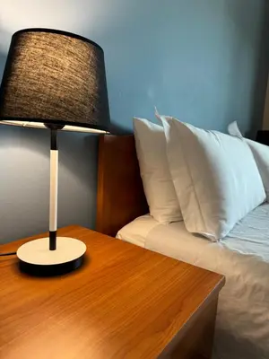 a lamp on a wooden table next to a bed at Palace Bed & Breakfast in Salaparuta