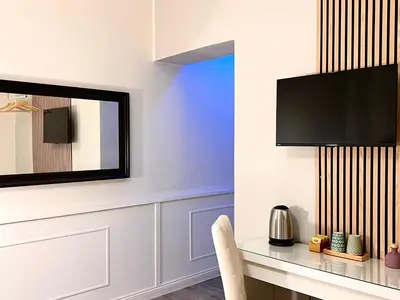 a room with a desk and a television on a wall at Villa di Nera B&B in Palermo