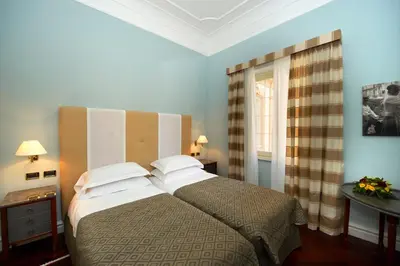 a bedroom with a large bed and a window at Grand Hotel Piazza Borsa in Palermo
