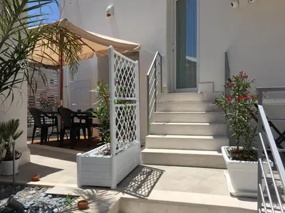 a house with stairs and a table and chairs at Charm Holiday in Terrasini