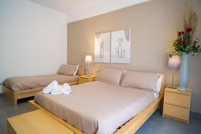 a bedroom with two beds and a vase with flowers at Enny Camere in Alcamo