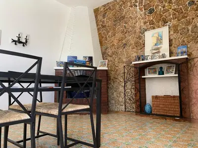 a dining room with a table and chairs and a fireplace at Casa Vacanze Astori in Trabia