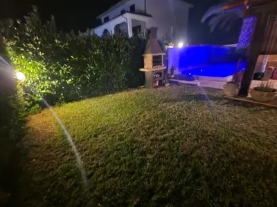 a backyard at night with a bird house on the grass at La Villetta di Leonardo, con piscina privata in Campofelice di Roccella