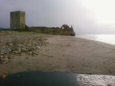 a castle on the shore of a beach with the water at La Villetta di Leonardo, con piscina privata in Campofelice di Roccella