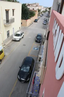 a black car parked on the side of a street at Locanda Lighea Rooms in San Vito lo Capo