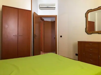 a bedroom with a green bed and a mirror at Casa Irene in San Vito lo Capo