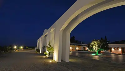 a white building with an arch at night at Tenute Plaia Agriturismo in Scopello