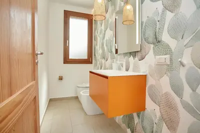 a bathroom with a toilet and a sink and a mirror at Villa dell'Artista in Scopello
