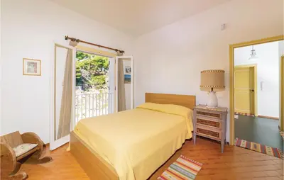 a bedroom with a bed and a table with a lamp at Villa Kericia in Porticello