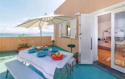 a table with a bowl of fruit and an umbrella at Villa Kericia in Porticello