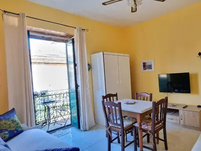 a dining room with a table and chairs and a window at Grazioso appartamento nel cuore di Palermo in Palermo
