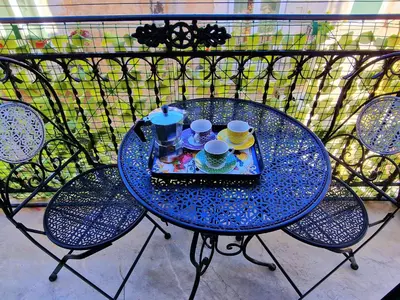 a blue table with cups and saucers on a balcony at Grazioso appartamento nel cuore di Palermo in Palermo