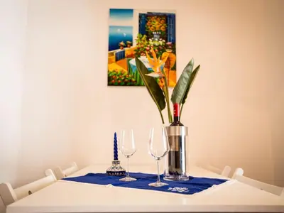 a table with two wine glasses and a vase at Appartamento gli archi a 100 metri dalla spiaggia in Castellammare del Golfo