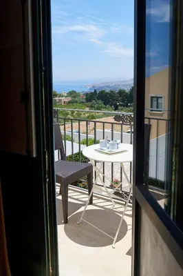 a table and chairs on a balcony with a view at Baglio Dello Zingaro in Scopello