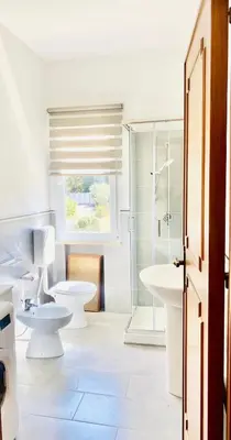a white bathroom with two toilets and a shower at Villa Eagle in Terrasini