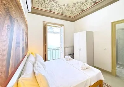 a bedroom with a bed and a large window at Solemar Sicilia - Monacò rooms in Palermo