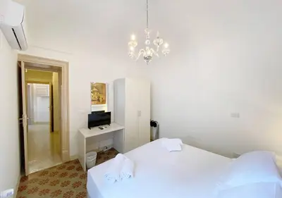 a bedroom with two white beds and a chandelier at Solemar Sicilia - Monacò rooms in Palermo
