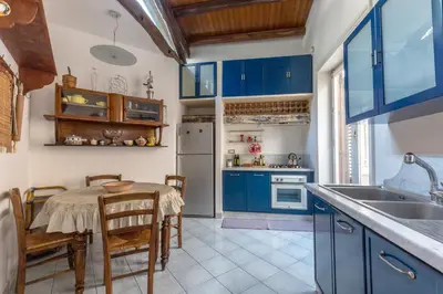 a kitchen with blue cabinets and a table with chairs at Terrazze di San Francesco by Wonderful Italy in Palermo