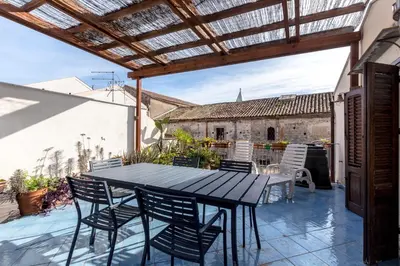 an outdoor patio with a black table and chairs at Terrazze di San Francesco by Wonderful Italy in Palermo