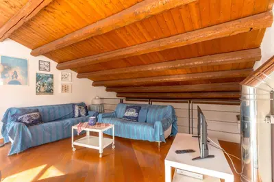 a living room with wooden ceilings and a blue couch at Terrazze di San Francesco by Wonderful Italy in Palermo