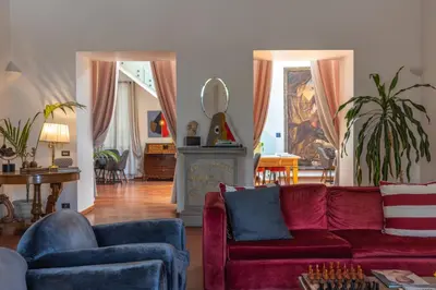 a living room with a red couch and blue chairs at L' Hôtellerie Easy Suites in Palermo
