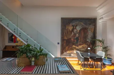a room with a painting and a table and chairs at L' Hôtellerie Easy Suites in Palermo