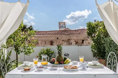 a table with fruit and drinks on a patio at Kalsa Casa di Charme con terrazza by Wonderful Italy in Palermo