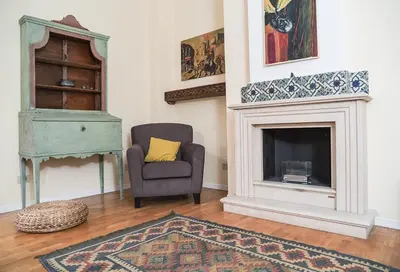 a living room with a chair and a fireplace at Kalsa Casa di Charme con terrazza by Wonderful Italy in Palermo