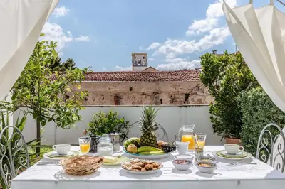 a white table with food on it on a patio at Kalsa Casa di Charme con terrazza by Wonderful Italy in Palermo
