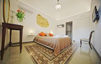 a bedroom with a bed and a table and a chair at Palazzo Torre Apartment in Palermo