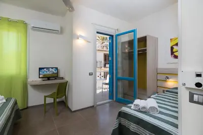 a bedroom with a bed and a desk with a computer at B&B Reef and Dream in San Vito lo Capo