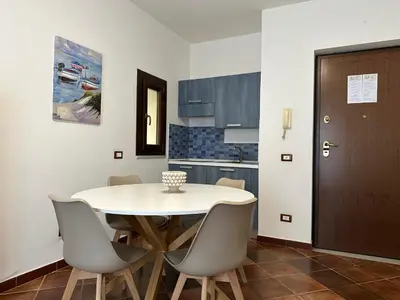 a kitchen with a table and chairs in a room at Appartamenti-Residence Al Massimo in Palermo