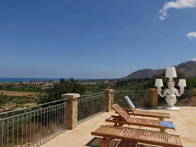 a balcony with chairs and a view of the mountains at Terrazze sul Tirreno in Lascari