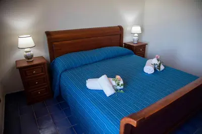 a bedroom with a bed with two dolls on it at Terrazze sul Tirreno in Lascari