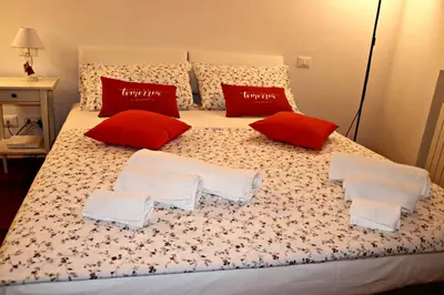 a large bed with red and white pillows on it at La Casetta di Clara in Palermo