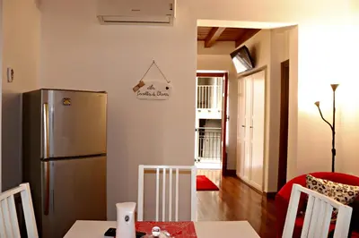 a kitchen with a refrigerator and a table with chairs at La Casetta di Clara in Palermo