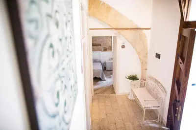 a view of a hallway with a table and a chair at B&B Cinisi Vacanze 2.0 in Cinisi
