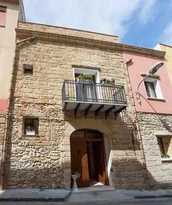 a brick building with a balcony and a door at B&B Cinisi Vacanze 2.0 in Cinisi
