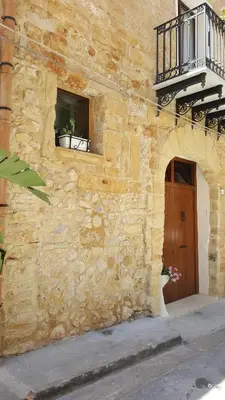 a stone building with a window and a balcony at B&B Cinisi Vacanze 2.0 in Cinisi