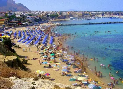 a beach with a bunch of people and umbrellas at B&B Cinisi Vacanze 2.0 in Cinisi