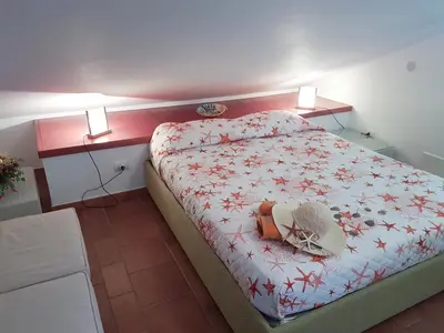 a small bedroom with a bed with a purse on it at Mansarda con Vista Piscina in Campofelice di Roccella
