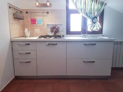 a white kitchen with a sink and a window at Mansarda con Vista Piscina in Campofelice di Roccella