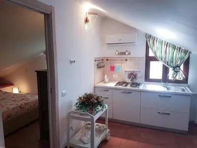a small kitchen with a sink and a stove at Mansarda con Vista Piscina in Campofelice di Roccella