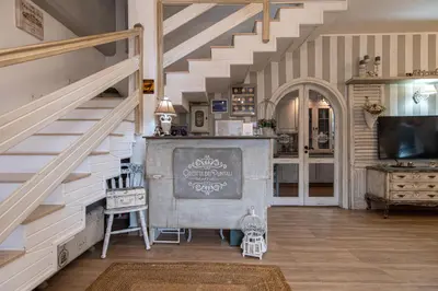 a staircase in a living room with a chandelier at Grotta dei Puntali B&B in Carini