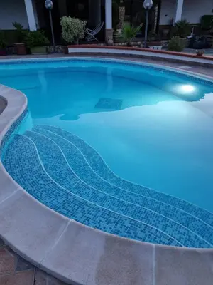 a swimming pool with blue tiles on it at Villa Sunshine in Balestrate