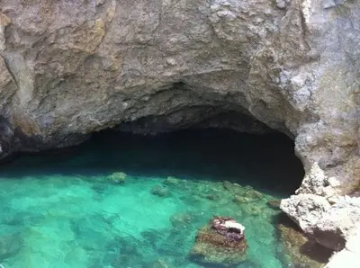 a cave in the water next to a large rock at Villa Sunshine in Balestrate
