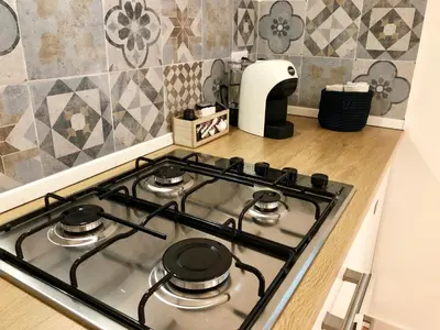 a stove top in a kitchen next to a counter at Mondello Beach Rooms - by the sea in Mondello