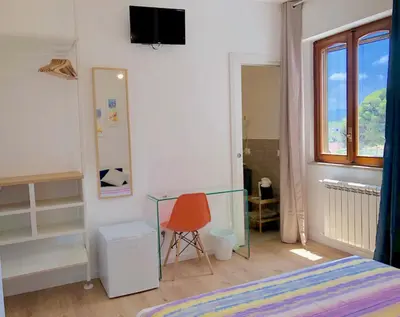 a bedroom with a bed and a glass table at Mondello Beach Rooms - by the sea in Mondello