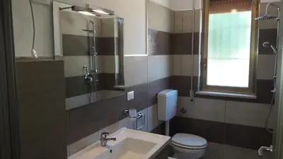 a bathroom with a sink and a toilet and a mirror at Casa Vacanze Reginotte in Balestrate